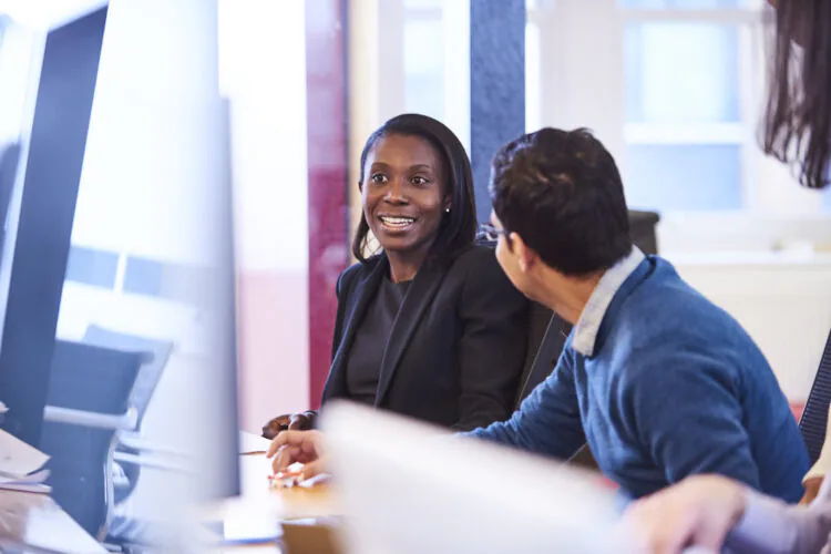 An image of two employees talking to each other.