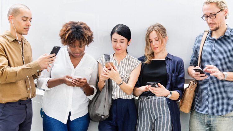 A group of people looking down at their phones.