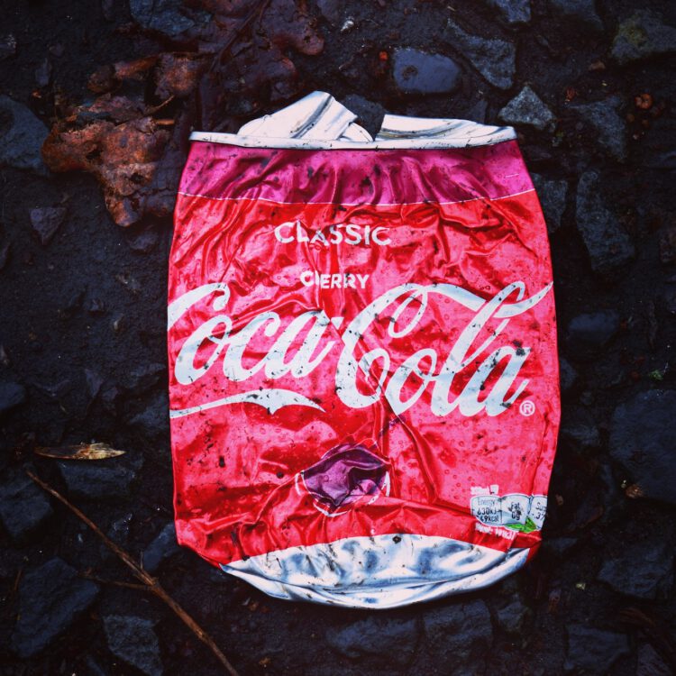 An image of a crushed cherry flavoured coco cola can.