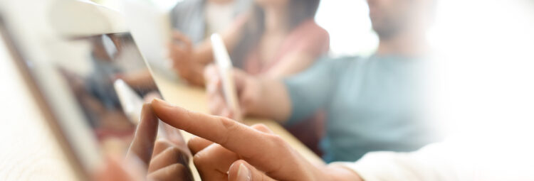 An image of someone touching an iPad screen.