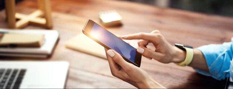 An image of a female holding a phone.