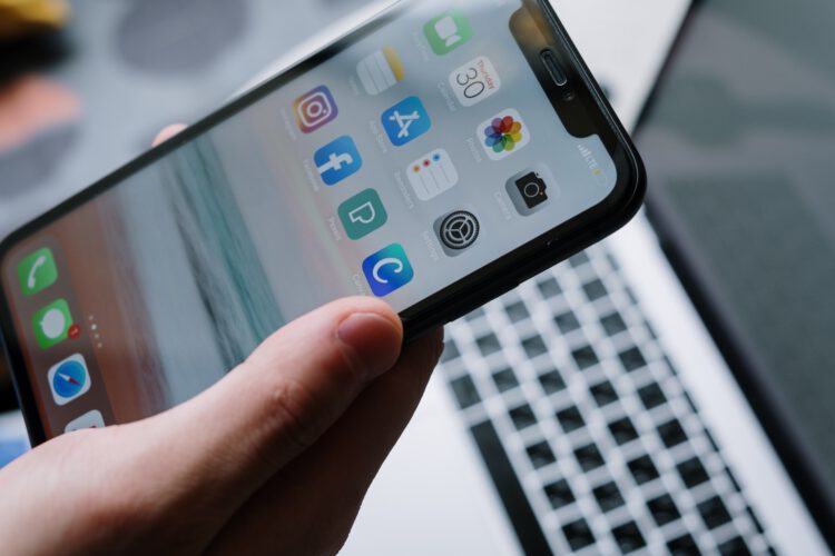 A close up shot of a iphone displaying its home screen.