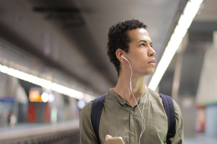 An image of a man walking with his headphones in.