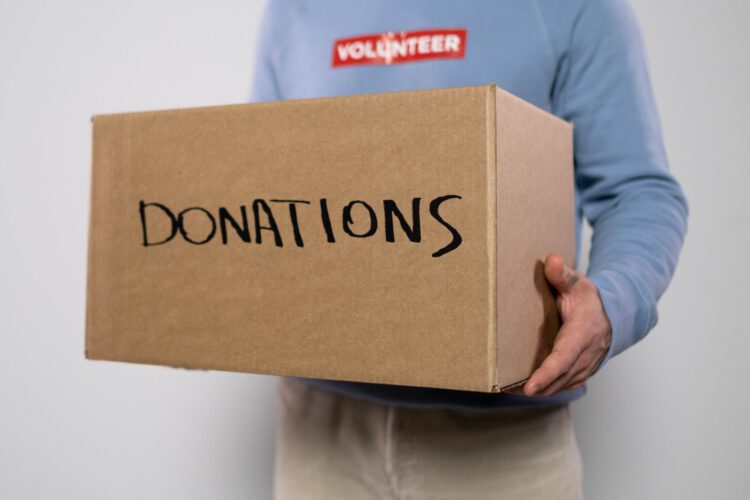 A volunteer holding a box full of donations.