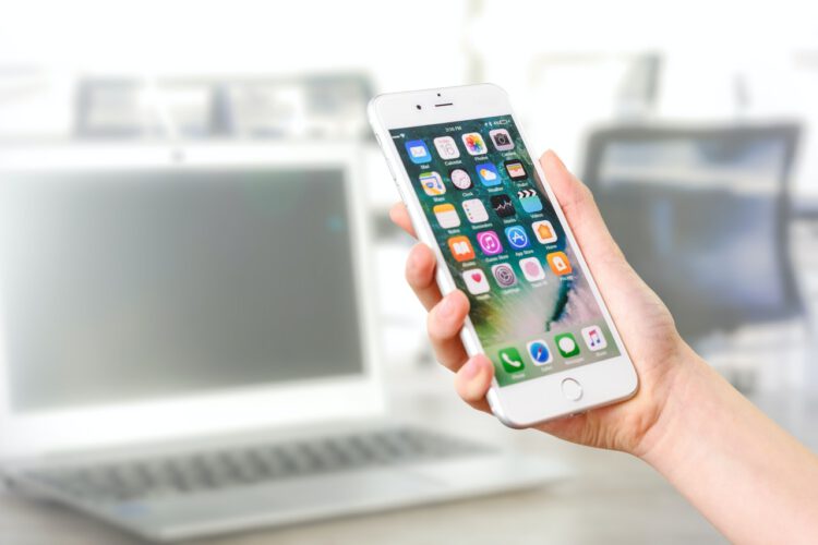 A hand holding a iPhone.