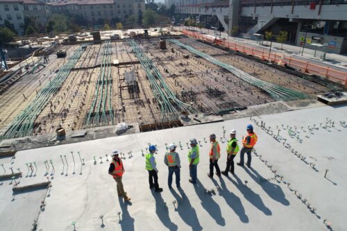 7 builders looking out at a construction site.