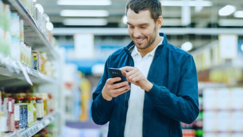 A customer in a store looking at his phone.